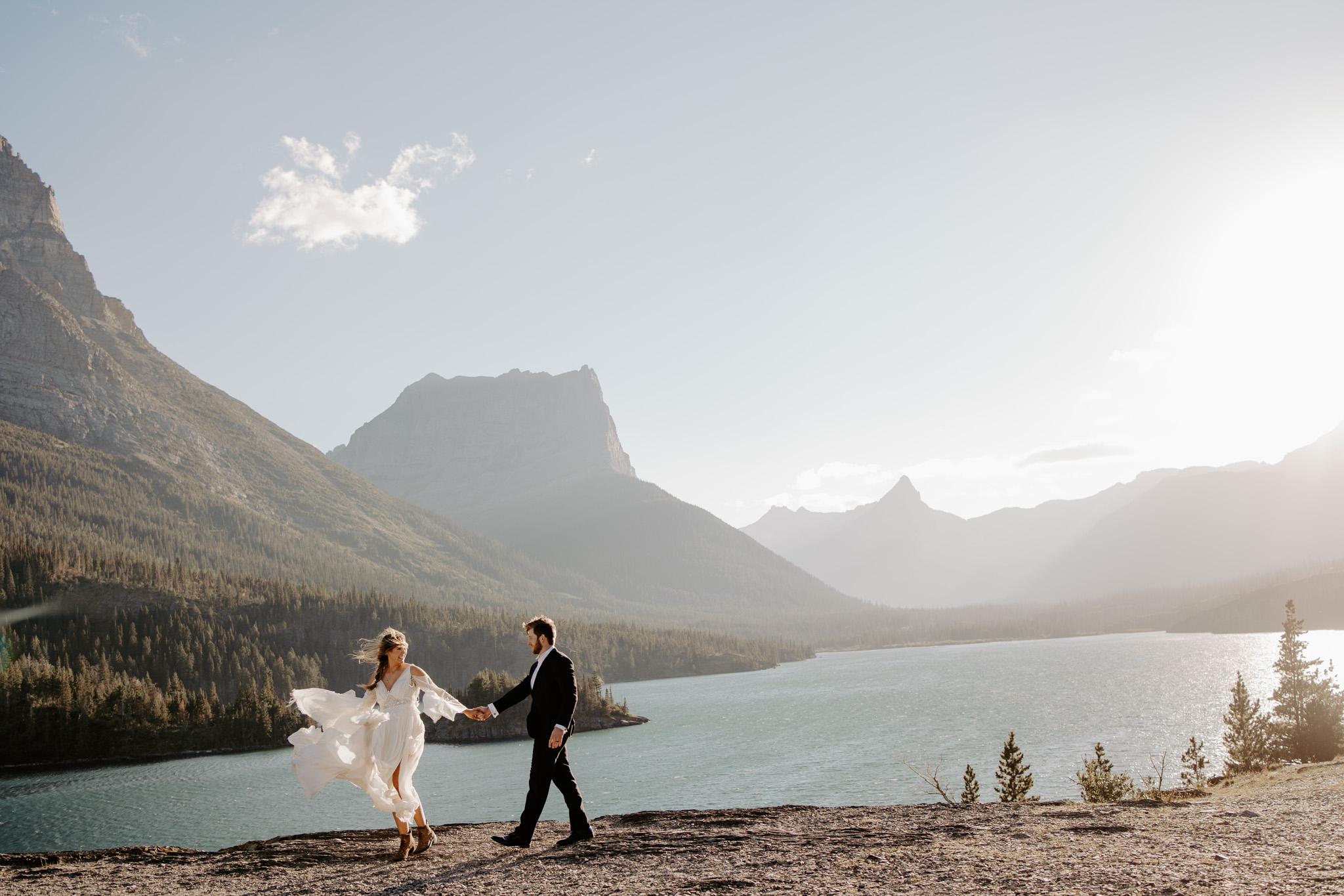 couple in glacier national park walking by the water