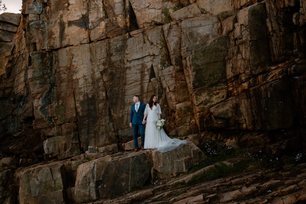 couple getting married against rock wall