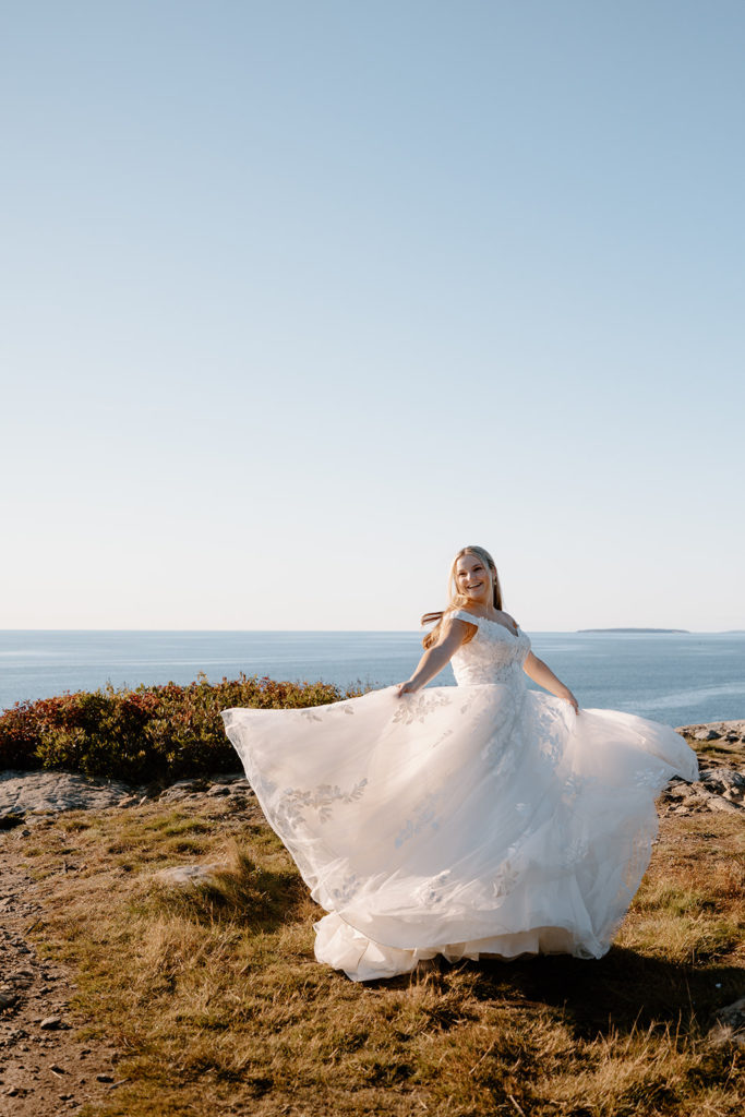 bride dancing in wedding dress by the ocean
