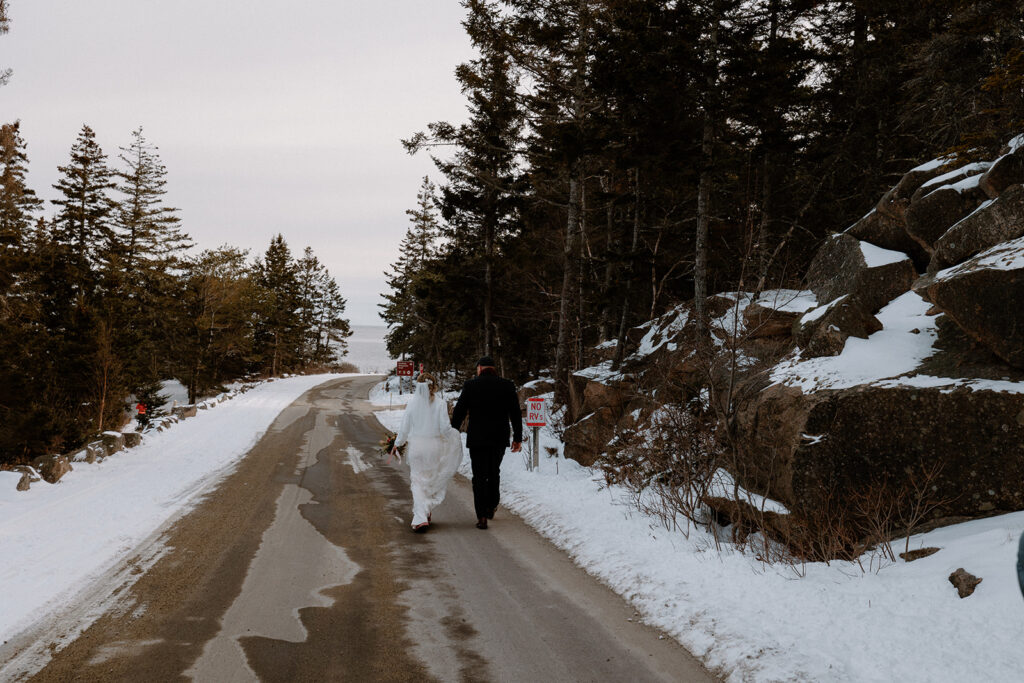 couple walking along the snowy loop road in Acadia